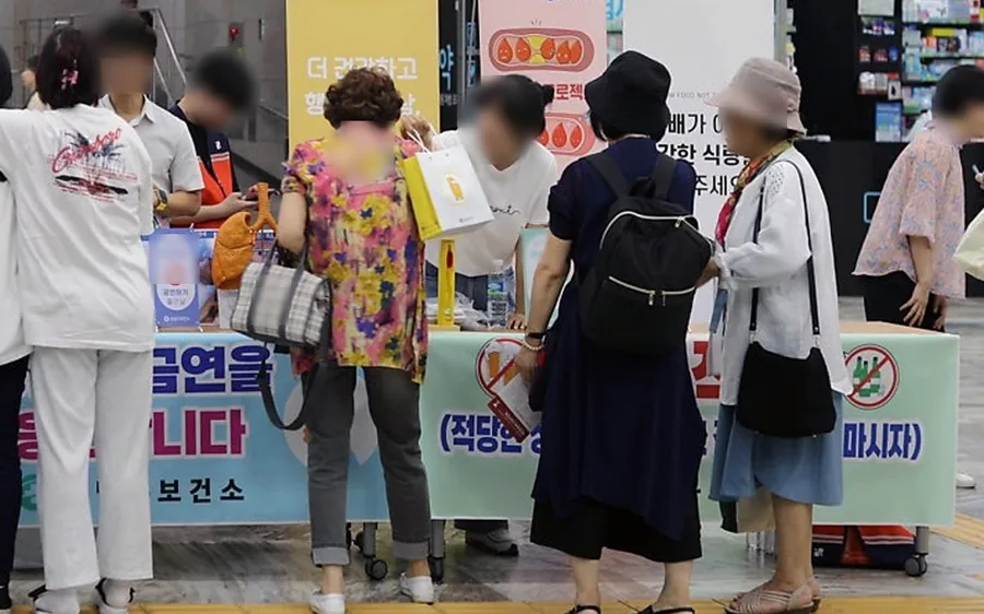 지하철역 행사 부스 앞에 시민들이 줄을 서서 설명을 듣는 장면